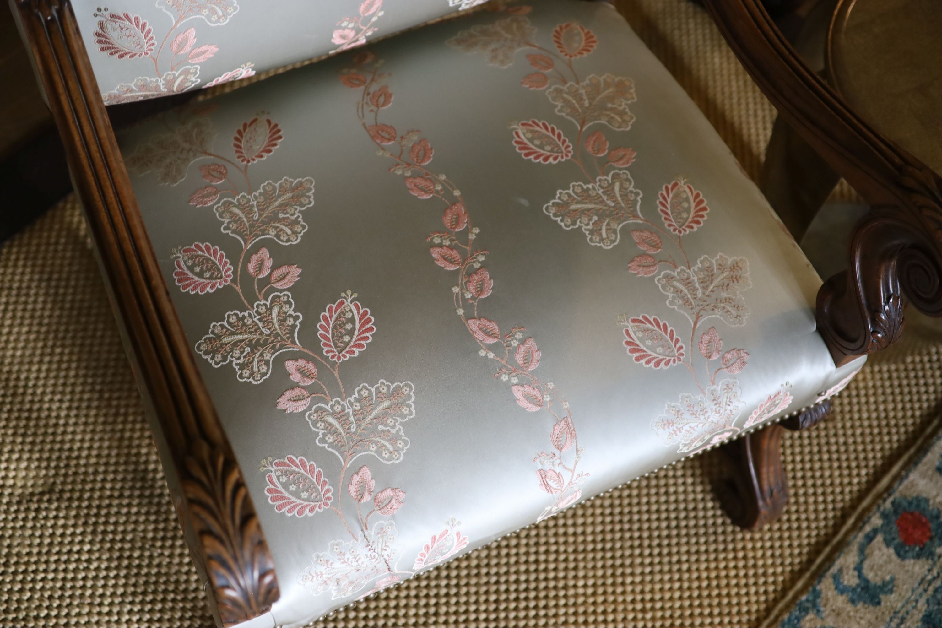 A pair of French carved walnut fauteuils, with machine embroidered Eau de Nil silk upholstery, width 66cm height 106cm